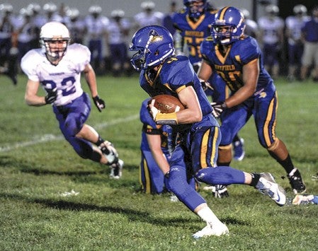 Hayfield’s Lane Canny carries in the second quarter against Goodhue in Hayfield last year. Herald file photo