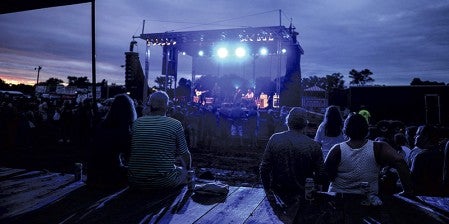 Fans watch from the back as Six Mile Grove finishes up its set Friday night at the Mower County Fairgrounds. Eric Johnson/photodesk@austindailyherald.com