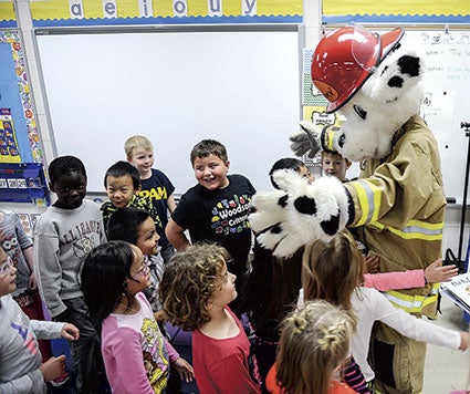 Sparky gets a welcome from Woodson Kindergarten Center students Tuesday morning. Eric Johnson/photodesk@austindailyherald.com