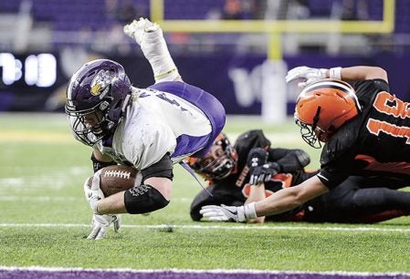 Grand Meadow’s Zach Myhre dives ahead for more yardages near the goalline against Cleveland-Immanuel Lutheran in the third quarter of the Minnesota State Nine Man Prep Bowl Friday morning at U.S. Bank Stadium. Eric Johnson/photodesk@austindailyherald.com