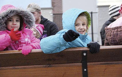 Makayla, 6, right and Maci Attleson, 5, wave during the horse-drawn sleigh ride at Wal-Mart. 
