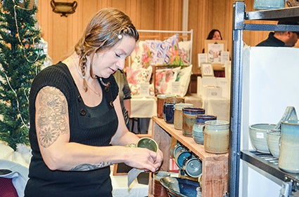 Heather Meyer, owner of Muddy Paw Ceramics, handles a mug during the Indie Craft Market, A Handmade Christmas, Friday evening.  Herald file photo