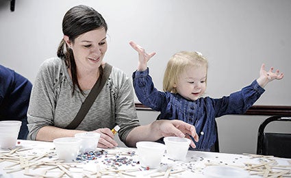 Colette Cook, 2, celebrates her mess while making her craft with her mom, Katie Cook, at the Austin Eagles Club. 