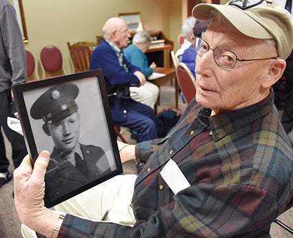 Les Buck of Austin displays his photograph, taken when he was just 20 and a member of the Quartermaster Corps.