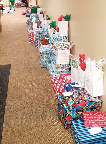 Several wrapped gifts are lined up against the wall at Health and Human Services. Photo provided