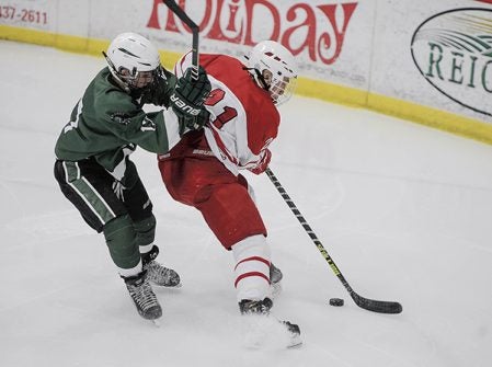 Austin’s Bryar Flanders fends off Faribault’s Nick Jandro during the first period Tuesday night at Riverside Arena. Eric Johnson/photodesk@austindailyherald.com