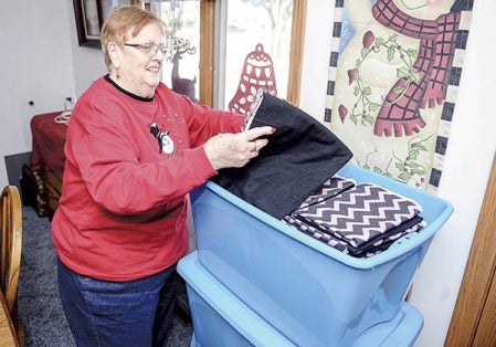 Barb Jackel digs through some of the flannel material she uses to make pillow cases which she gives away. Eric Johnson/photodesk@austindailyherald.com