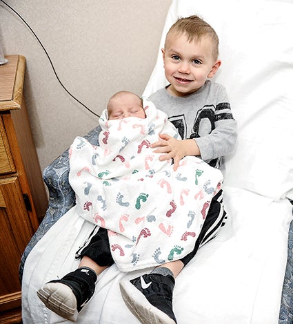 Two and a half-year-old Brody Lang holds his new baby brother at the Mayo Healthcare System-Austin Tuesday evening. 