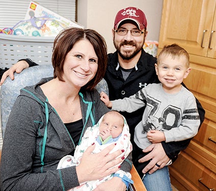 Kelly and Mark Lang take a family picture with their newborn son Weston and two and a half year old son Brody.
