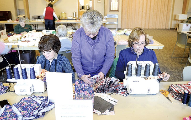 Maridee Ofstedahl, from left, Jacky Dietz and Ann Sundal sew and assemble female hygiene kits during an annual workshop at Westminster Presbyterian Church Wednesday.  Eric Johnson/photodesk@austindailyherald.com