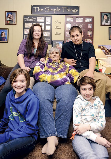 Marsha Pawluk sits surrounded by some of her foster children in 2014. Herald file photo