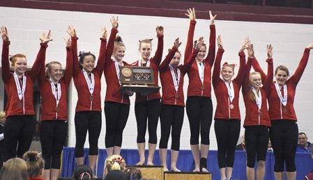 The Austin Packers on the podium after they were awarded the third place trophy at the Minnesota Class A State Gymnastics Meet Friday at the University of Minnesota’s Sports Pavillion. Rocky Hulne/sports@austindailyherald.com