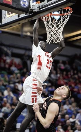 Austin’s Duoth Gach dunks over Marshall’s Reece Winkelman in the first half in the semifinals of the Minnesota Class AAA Boys State Basketball Tournament Thursday at Target Center in Minneapolis. Eric Johnson/photodesk@austindailyherald.clom