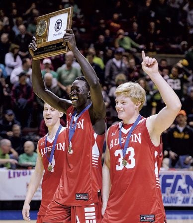 Austin’s Both Gach along with fellow captains Tate Hebrink and Kyle Oberbroeckling hold up the Section 1AAA championship trophy after defeating Northfield at Mayo Civic Center Friday night. Eric Johnson/photodesk@austindailyherald.com