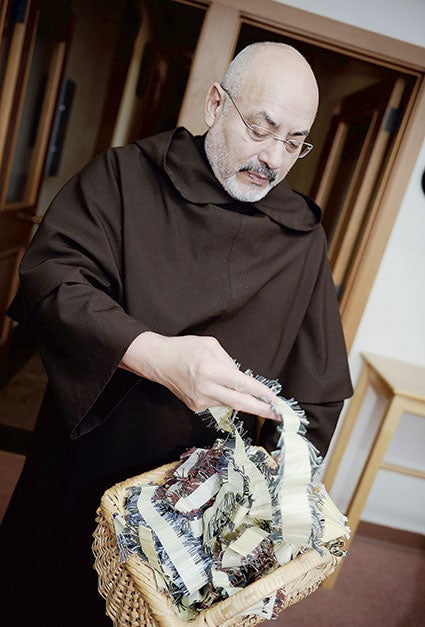 Brother Henry shows off some of the fabric used in creating the rugs at the Annunciation Hermitage Order of Carmelites in Austin. Eric Johnson