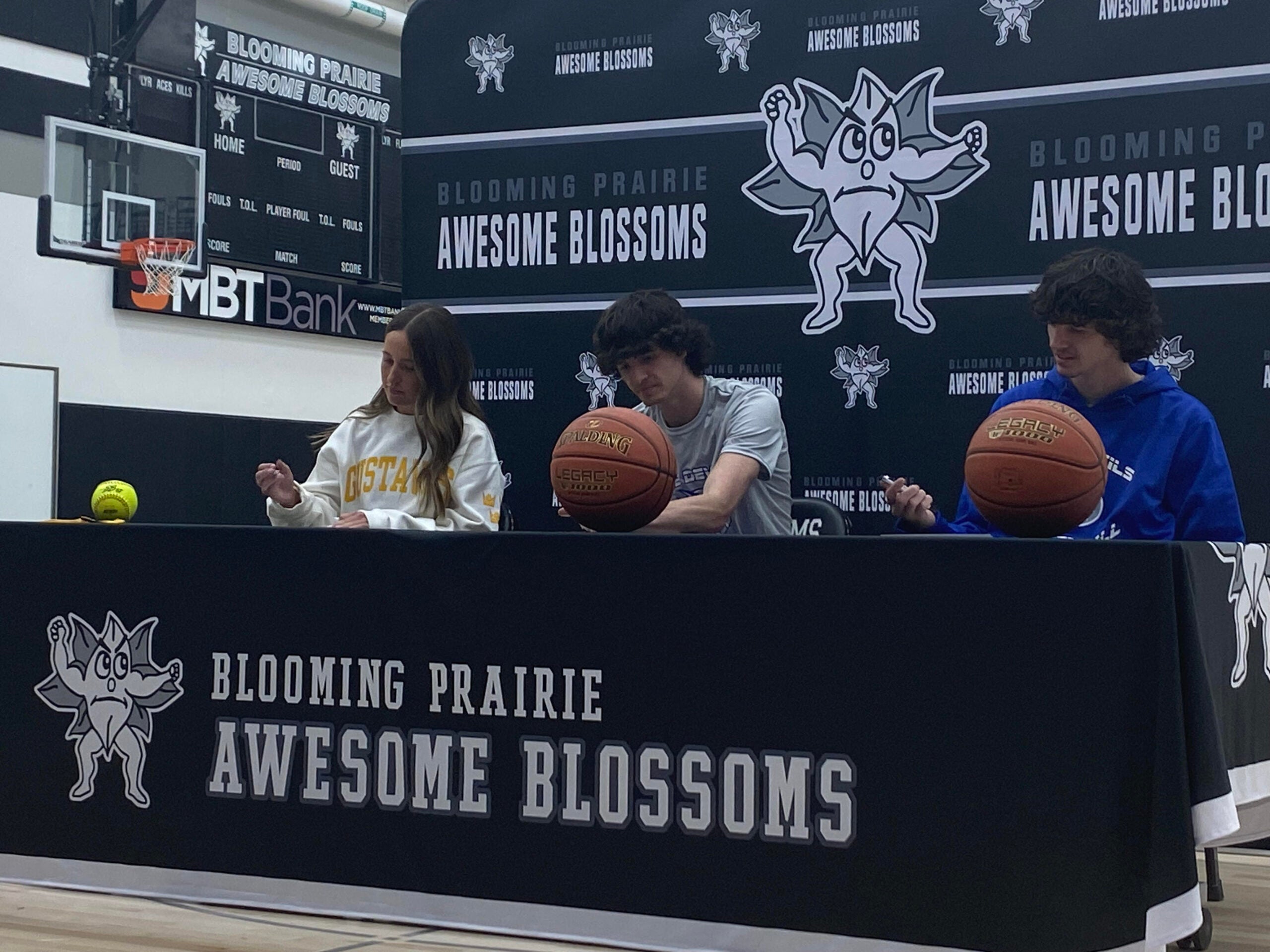 Blooming Prairie seniors Macy Lembke, Gabe Hein and Zack Hein sign their celebration letters at Blooming Prairie High School Friday. Rocky Huln/sports@austindailyherald.com